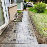concrete patio with a walkway leading to the side yard